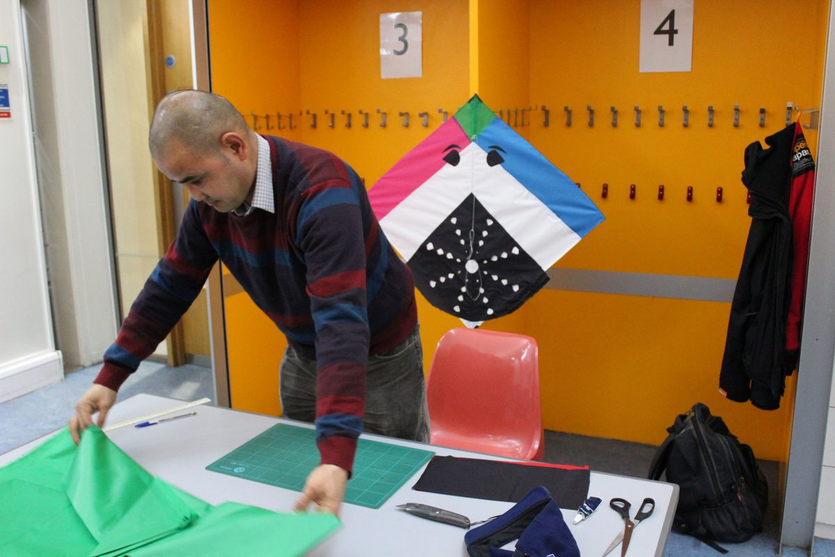 Ahmadzia laying out materials to make kites