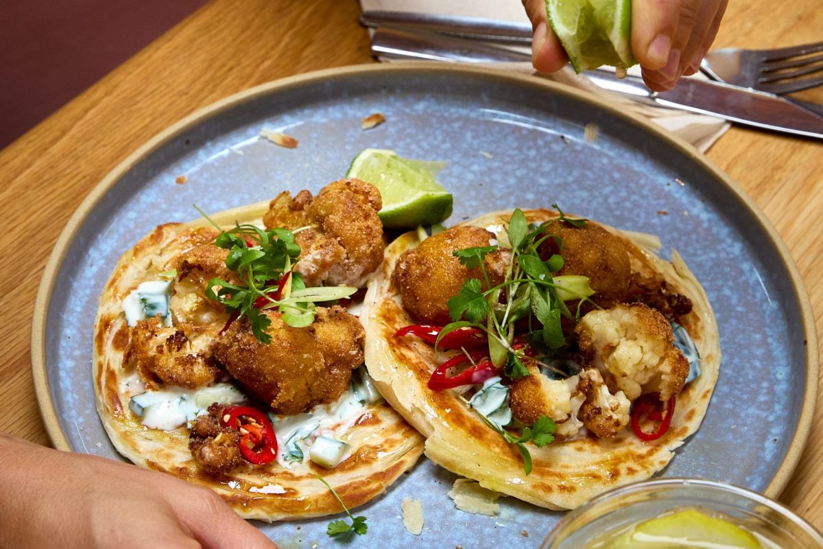 Lime being squeezed on cauliflower flatbread