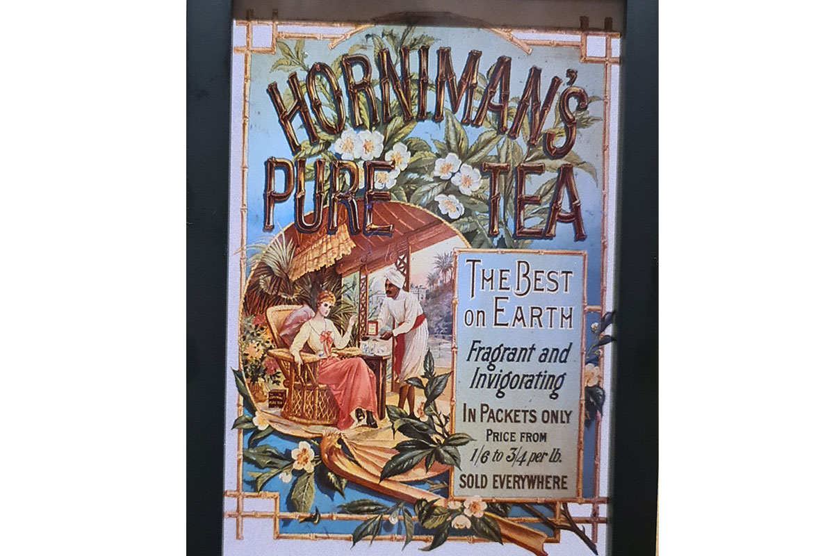 Horniman's Pure Tea advert showing a white woman being served tea by a south asian man. The text reads 'The best on earth fragrant and invigorating in packets only'