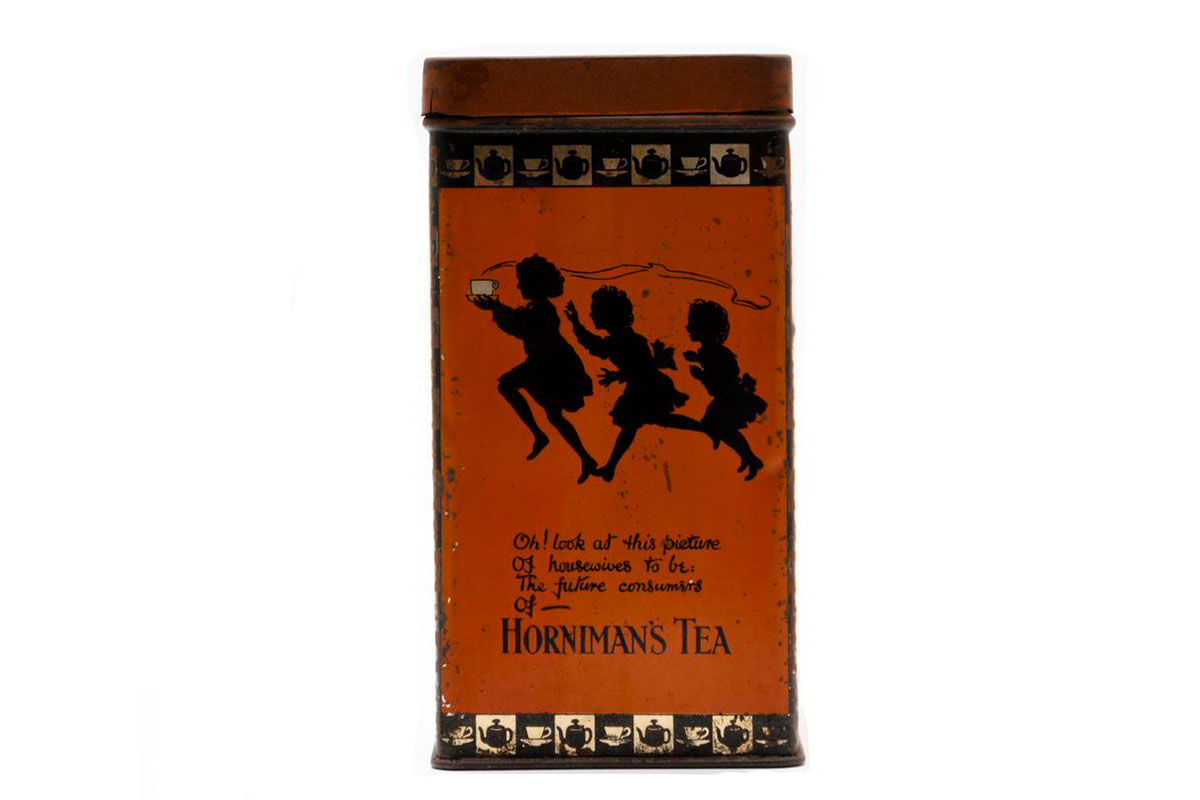 Tea caddy depicting the silhouettes of three children, one of which is holding a cup of tea. The text reads 'Oh look at this picture of housewives to be, the future consumers of Horniman's Tea'